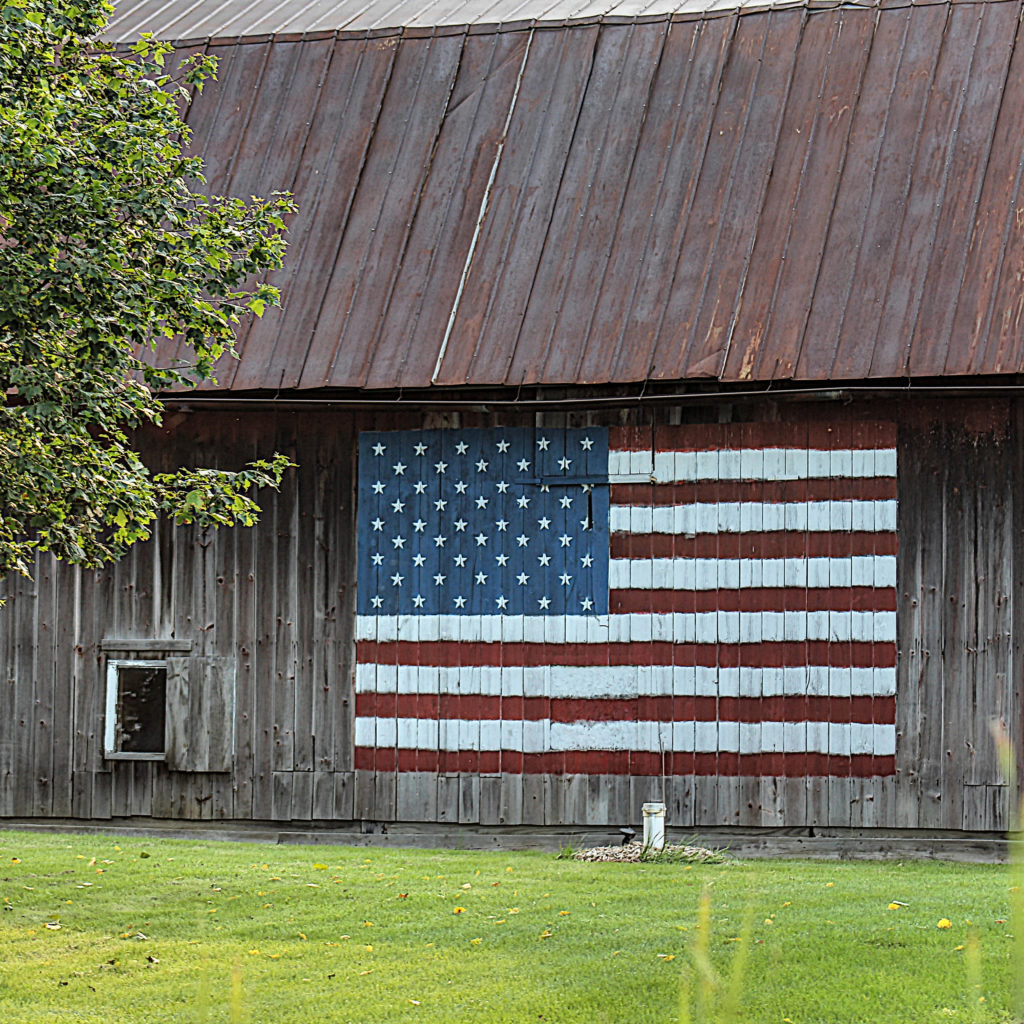 painted-barn old barn with a painting of the American flag on the side in nostalgic photography