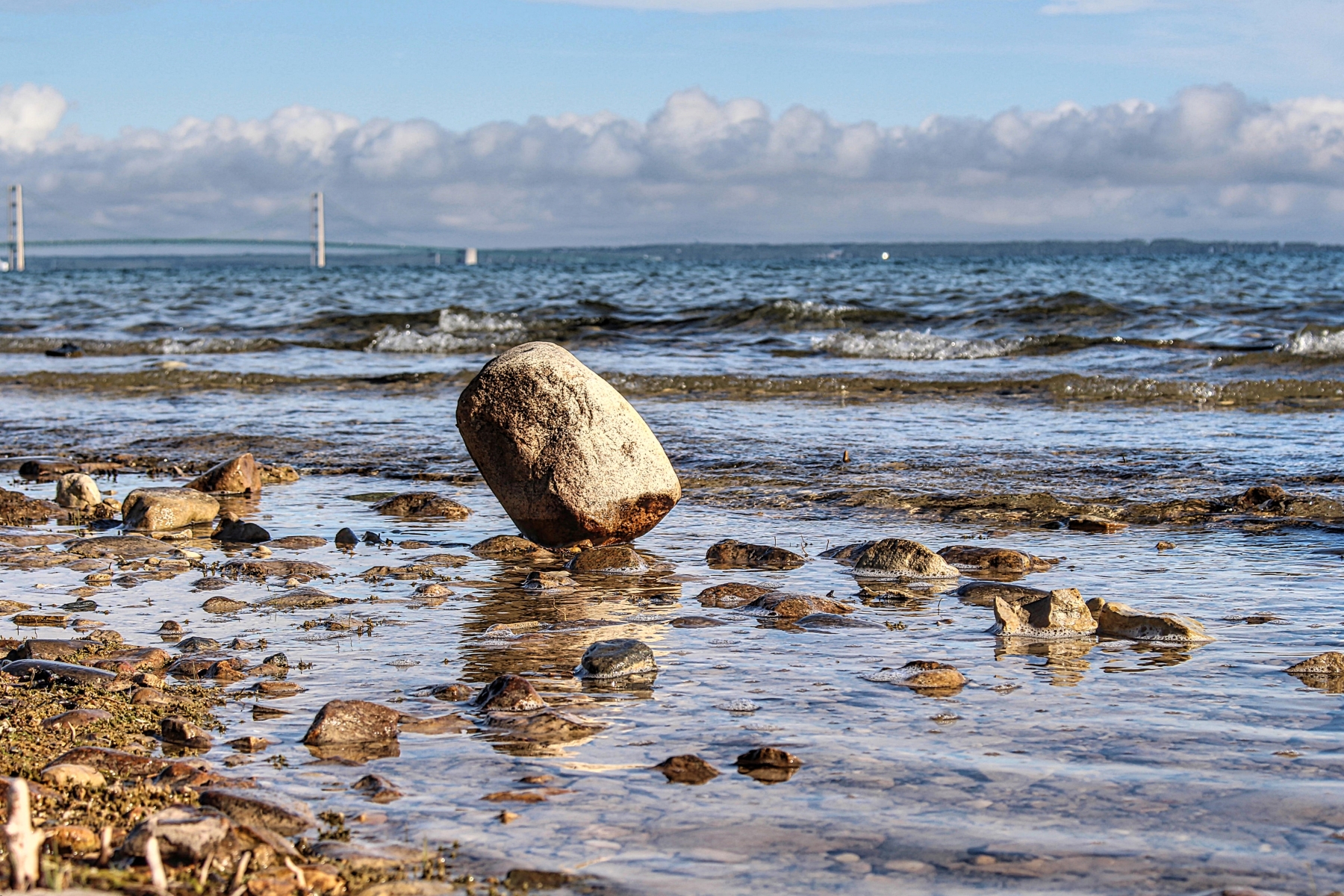 large boulder tilted up on one side on a rocky beach of lake huron